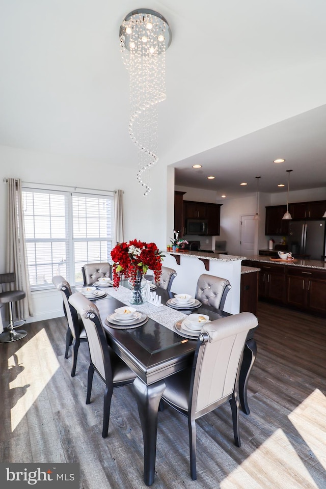 dining space featuring dark hardwood / wood-style floors and a chandelier