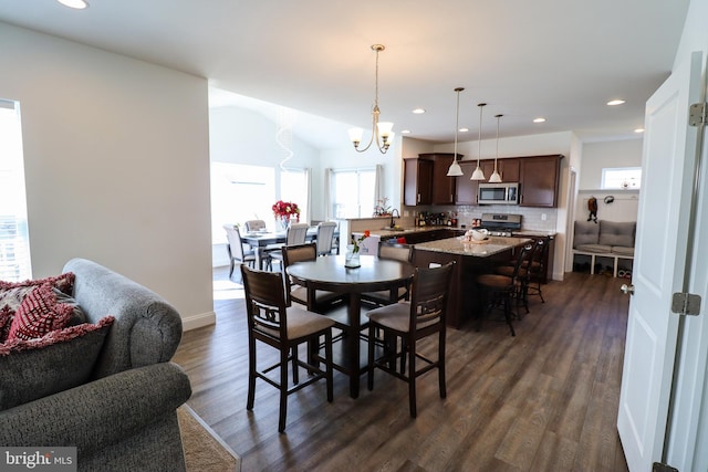 dining space featuring dark hardwood / wood-style floors, an inviting chandelier, and sink