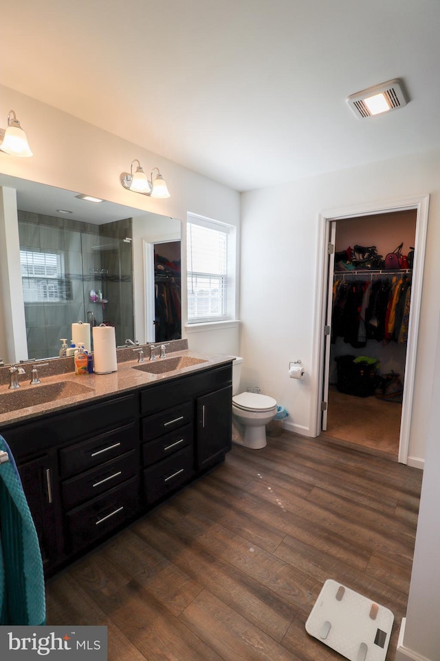 bathroom featuring a shower with shower door, toilet, hardwood / wood-style floors, and vanity