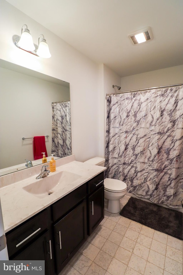 bathroom featuring vanity, toilet, and curtained shower