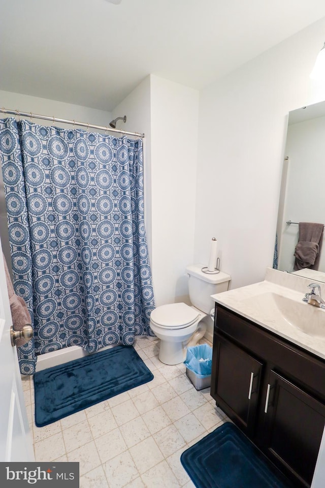 bathroom featuring vanity, toilet, and a shower with shower curtain