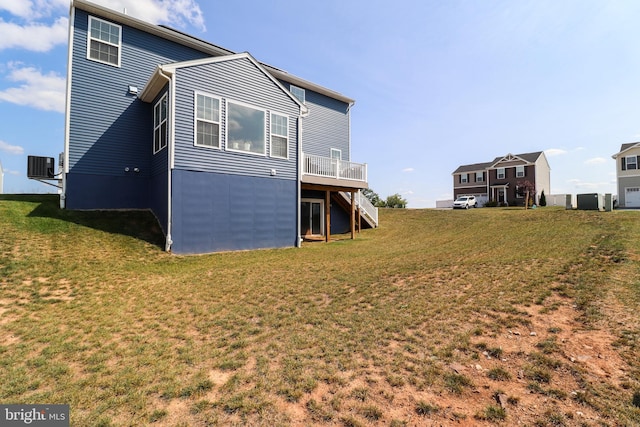 rear view of property with a lawn and cooling unit