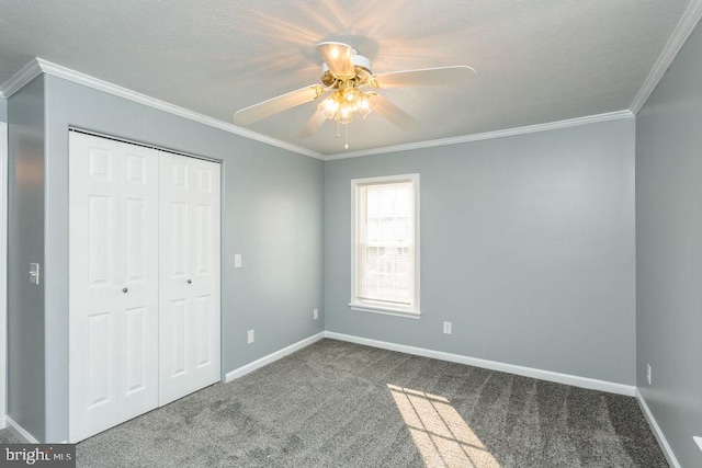 unfurnished bedroom with ornamental molding, a closet, ceiling fan, and carpet