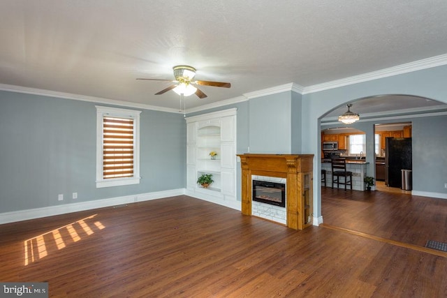 unfurnished living room with a textured ceiling, ceiling fan, ornamental molding, and dark hardwood / wood-style flooring