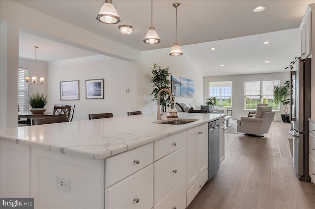 kitchen featuring open floor plan, recessed lighting, appliances with stainless steel finishes, wood finished floors, and a sink