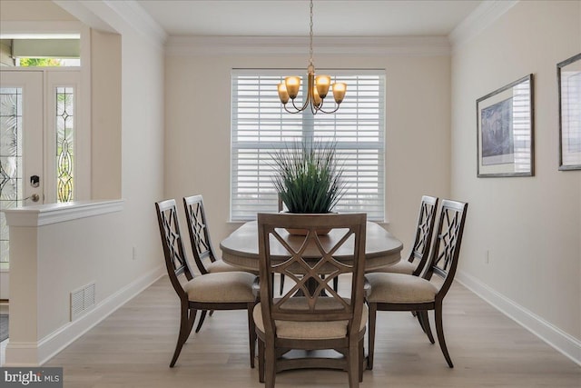 dining area with visible vents, crown molding, baseboards, a chandelier, and light wood-type flooring