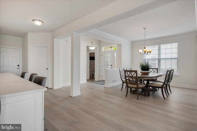 dining room featuring light wood-style flooring, an inviting chandelier, baseboards, and ornamental molding