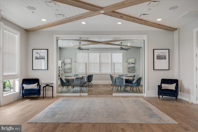 living area featuring visible vents, baseboards, lofted ceiling with beams, recessed lighting, and wood finished floors