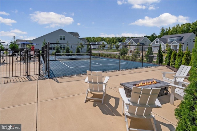 view of sport court with a residential view, a fire pit, and fence