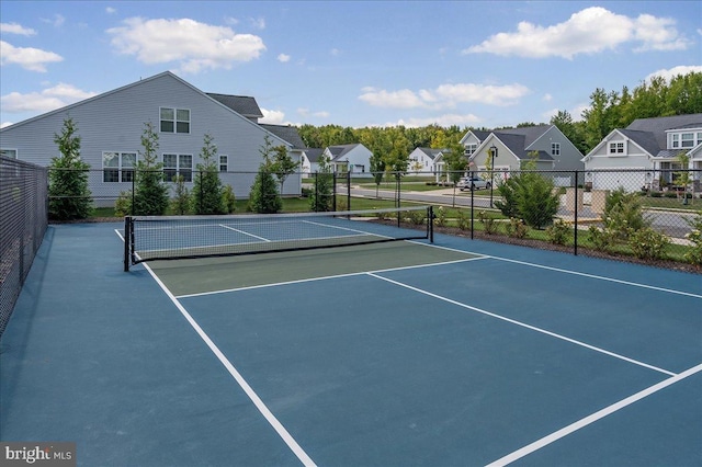 view of sport court featuring fence and a residential view