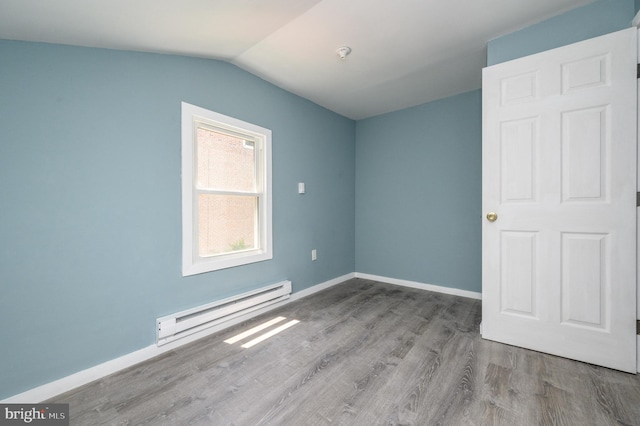 empty room with a baseboard radiator, vaulted ceiling, and light hardwood / wood-style flooring