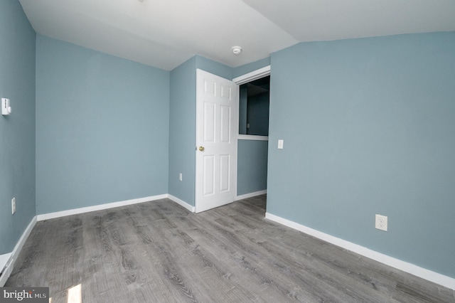 empty room with lofted ceiling and light hardwood / wood-style flooring