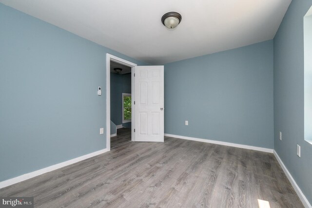 empty room featuring a wall mounted AC and hardwood / wood-style flooring