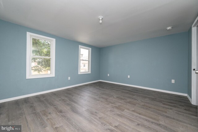 spare room featuring hardwood / wood-style floors and a wall unit AC