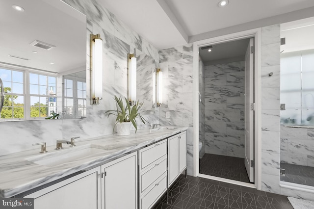 bathroom featuring vanity, tiled shower, toilet, and tile walls