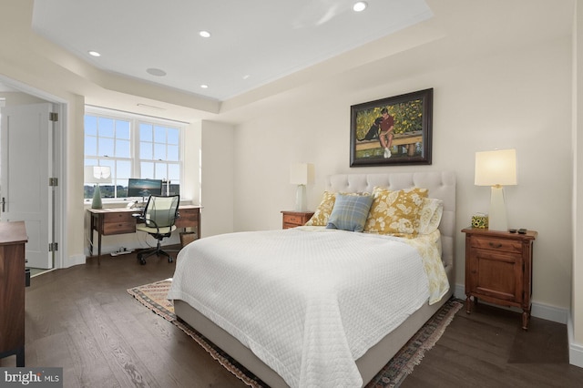 bedroom featuring a tray ceiling and dark hardwood / wood-style flooring