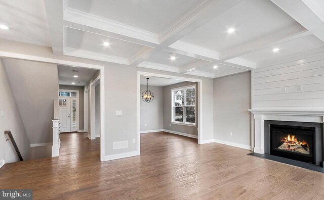 unfurnished living room featuring crown molding, coffered ceiling, beam ceiling, and hardwood / wood-style flooring