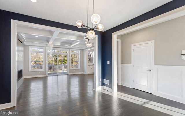 unfurnished dining area with a notable chandelier, beamed ceiling, coffered ceiling, and dark hardwood / wood-style flooring