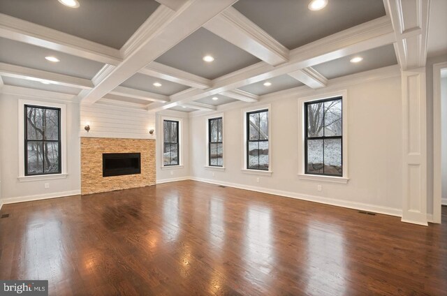 unfurnished living room featuring dark hardwood / wood-style flooring, beam ceiling, coffered ceiling, a fireplace, and crown molding