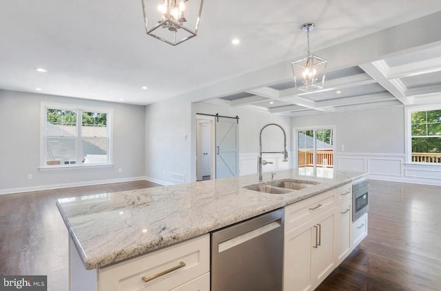 kitchen with white cabinetry, a barn door, stainless steel appliances, decorative light fixtures, and sink