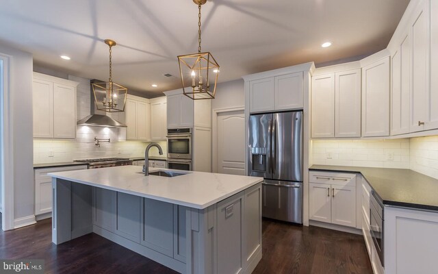 kitchen with wall chimney exhaust hood, stainless steel appliances, white cabinets, and decorative light fixtures