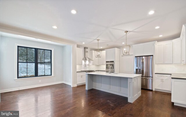 kitchen featuring pendant lighting, an island with sink, stainless steel fridge with ice dispenser, wall chimney range hood, and dark hardwood / wood-style floors