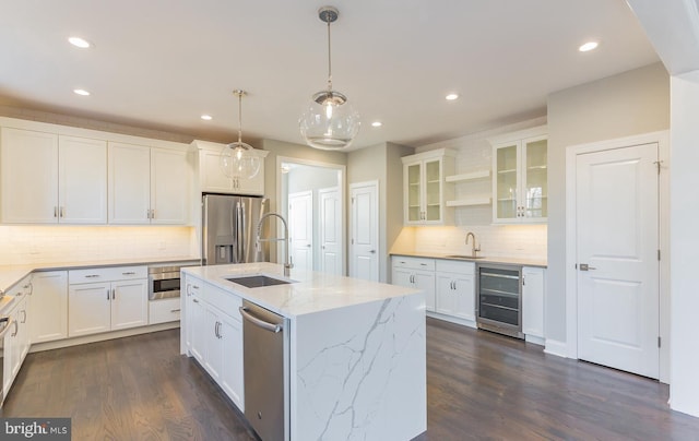 kitchen featuring white cabinets, wine cooler, a center island with sink, and dark wood-type flooring