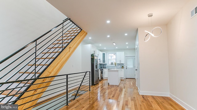 hallway with visible vents, recessed lighting, light wood-style floors, and baseboards