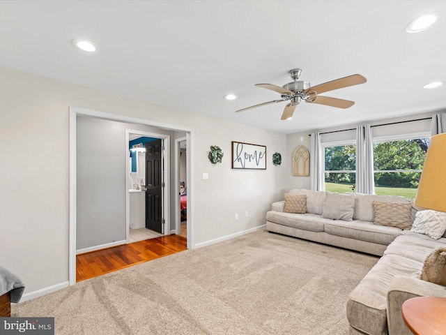 living room featuring ceiling fan and light hardwood / wood-style flooring