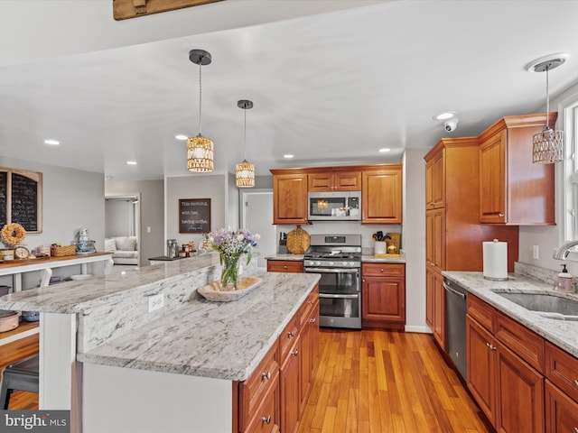 kitchen with a spacious island, a breakfast bar, sink, and appliances with stainless steel finishes