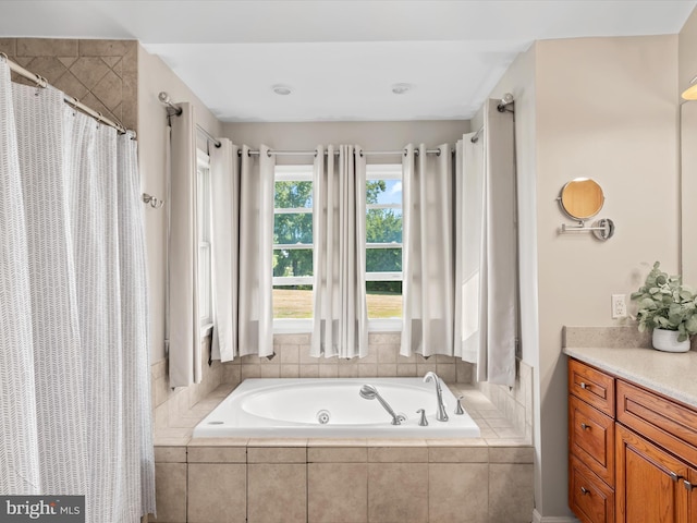 bathroom featuring tiled bath and vanity