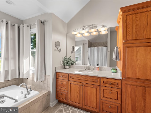 bathroom featuring lofted ceiling, tile patterned floors, tiled bath, and vanity