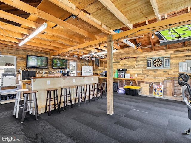 interior space featuring carpet, wood walls, and indoor bar