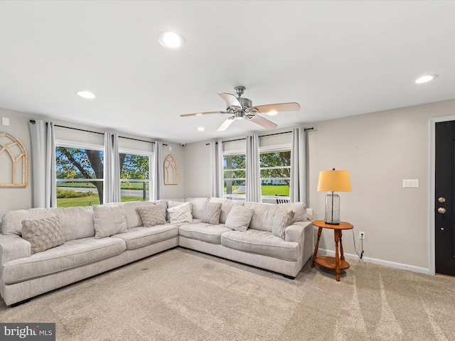 living room with light colored carpet and ceiling fan