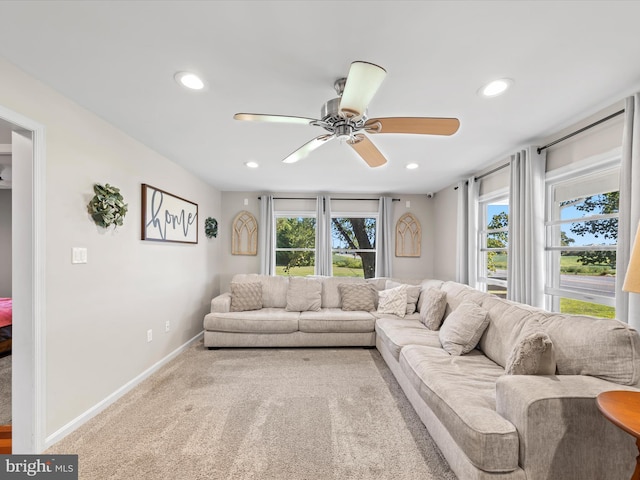 carpeted living room featuring plenty of natural light and ceiling fan