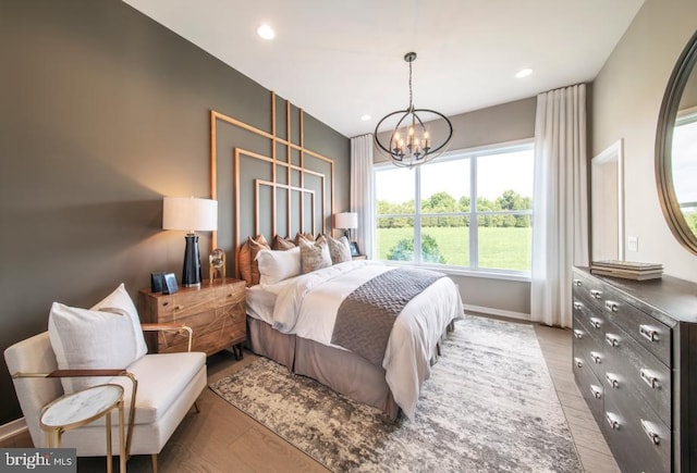 bedroom with a chandelier and light hardwood / wood-style flooring