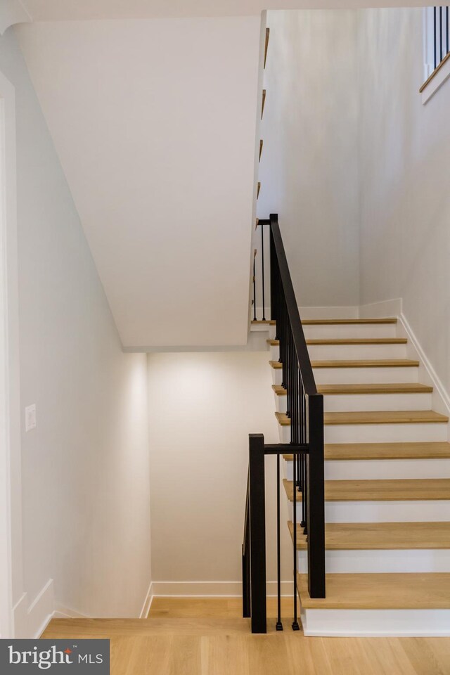 stairway with hardwood / wood-style flooring