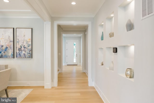 corridor with light wood-type flooring and ornamental molding