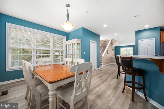 dining room with visible vents, recessed lighting, light wood-style floors, baseboards, and stairs