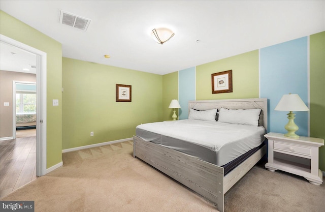 carpeted bedroom with baseboards and visible vents