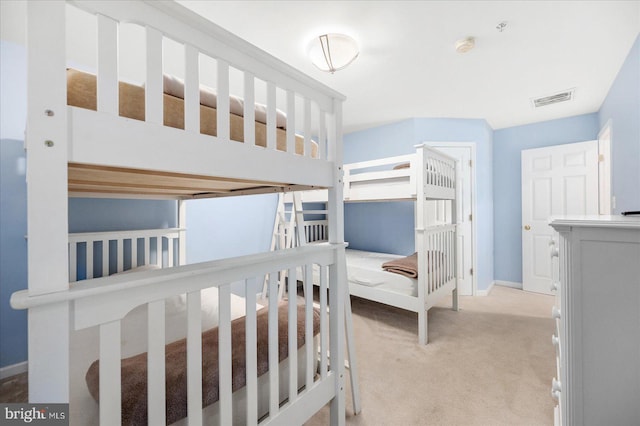 bedroom with baseboards, visible vents, and light carpet