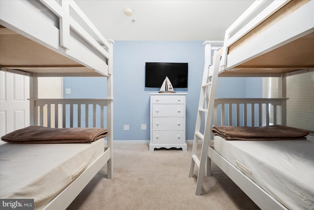 bedroom with baseboards and light carpet