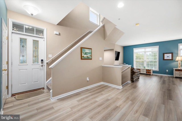 entryway featuring stairway, baseboards, and wood finished floors