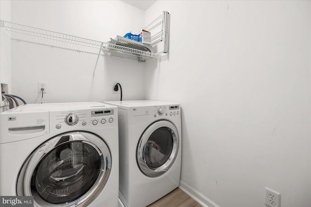 laundry area featuring laundry area, light wood-style floors, independent washer and dryer, and baseboards