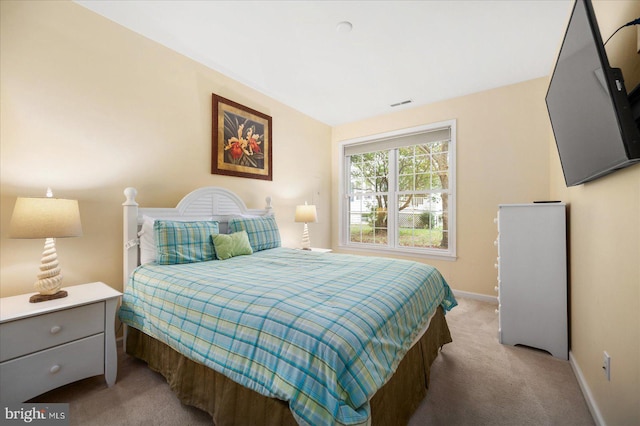 bedroom featuring visible vents, baseboards, and light carpet