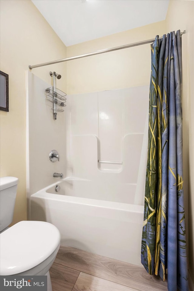 bathroom featuring toilet and shower / bathtub combination with curtain