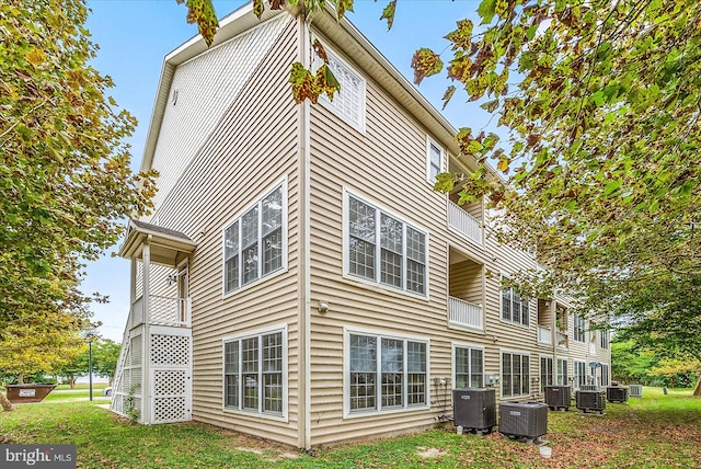 back of house with a lawn and central AC