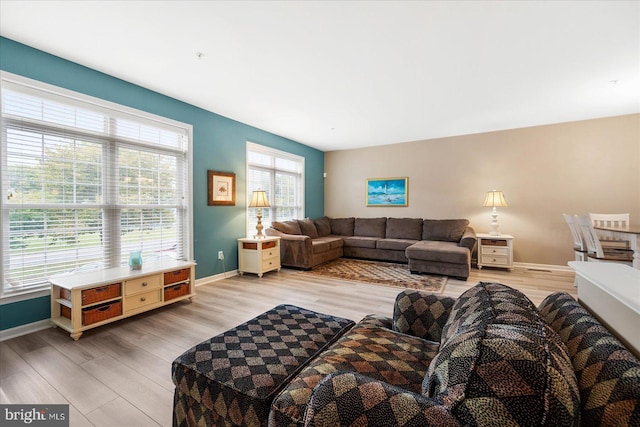 living area with baseboards and light wood-type flooring