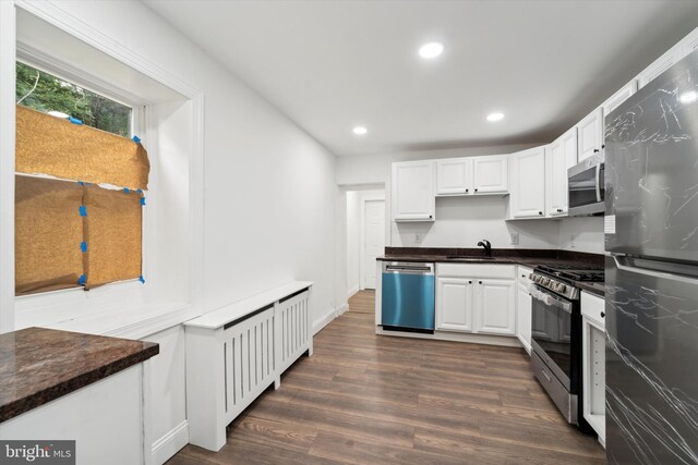 kitchen with white cabinets, sink, appliances with stainless steel finishes, and dark wood-type flooring