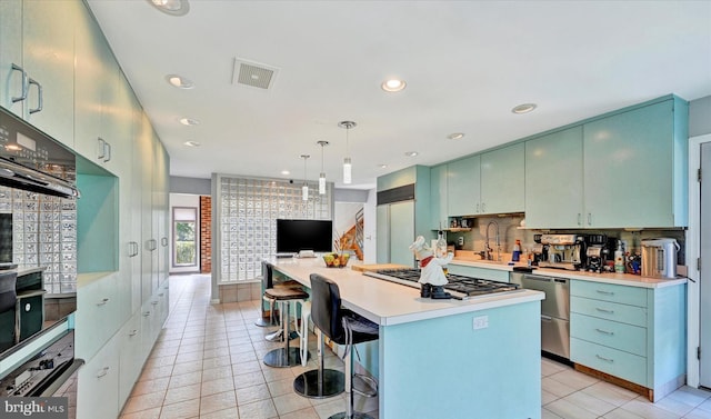 kitchen with visible vents, appliances with stainless steel finishes, a breakfast bar area, light countertops, and light tile patterned floors